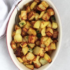 Golden brown air fried diced potatoes in a serving dish.