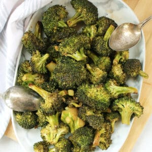 Balsamic broccoli served on a plate with two spoons.