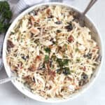 Creamy Mediterranean slaw in a bowl and garnished with fresh parsley.