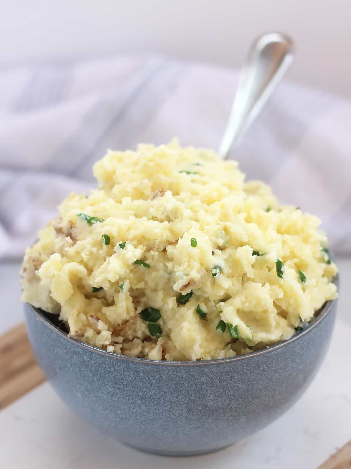Buttery mashed potatoes in a bowl with a spoon.