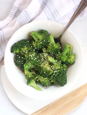 A spoon in a bowl of Chinese broccoli.
