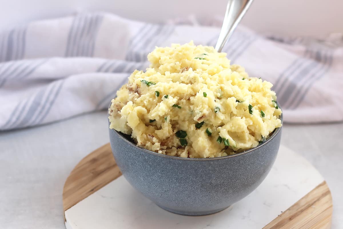 Air fryer mashed potatoes and chives served in a blue bowl.
