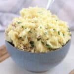 Fluffy mashed potatoes in a bowl with a spoon.