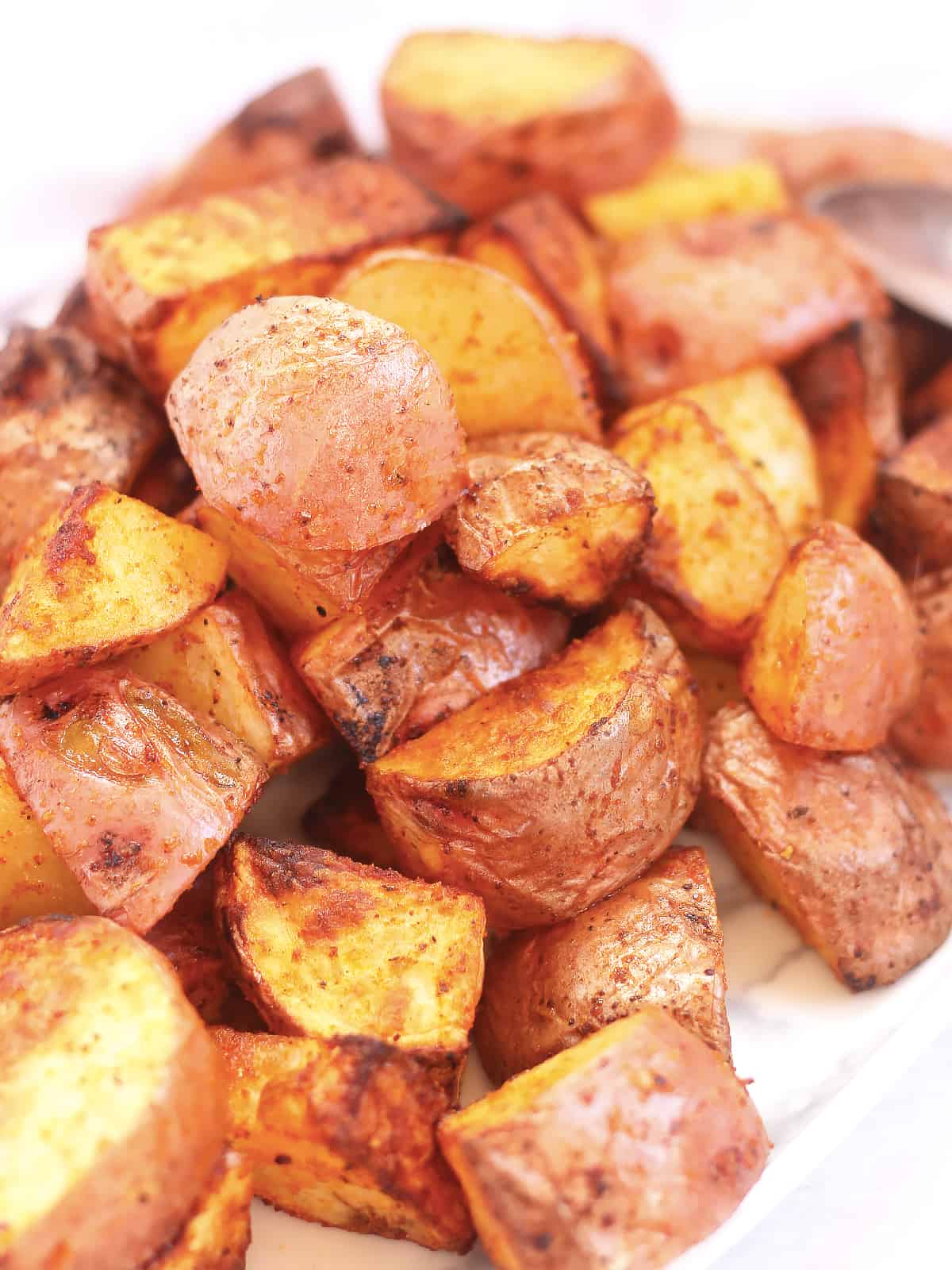Red skinned roasted potatoes piled on top of each other.