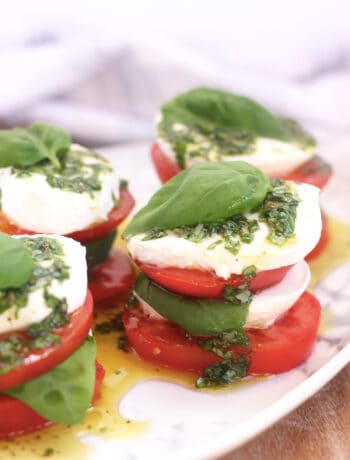 Caprese salad stacks drizzled with basil olive oil.