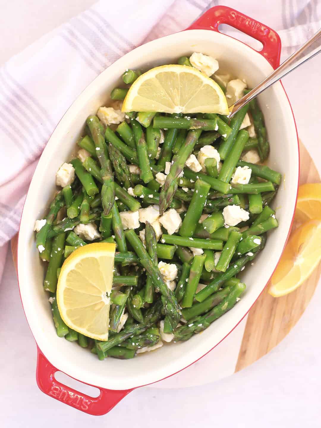 Asparagus, feta and lemon salad served in a bowl with a spoon.