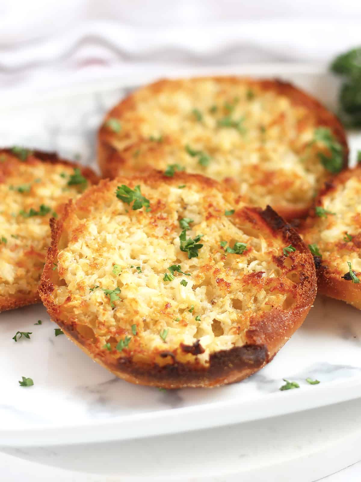 Golden brown English muffin with parmesan and garlic butter.