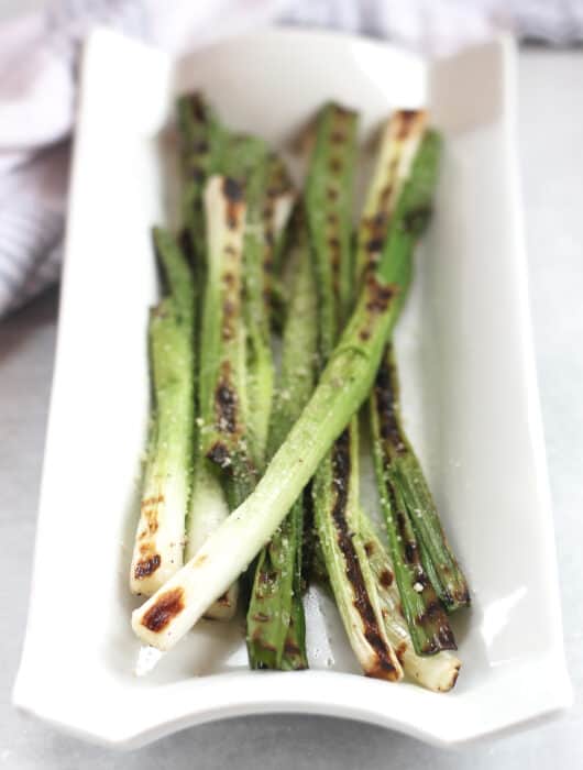 Grilled green onions with char marks.