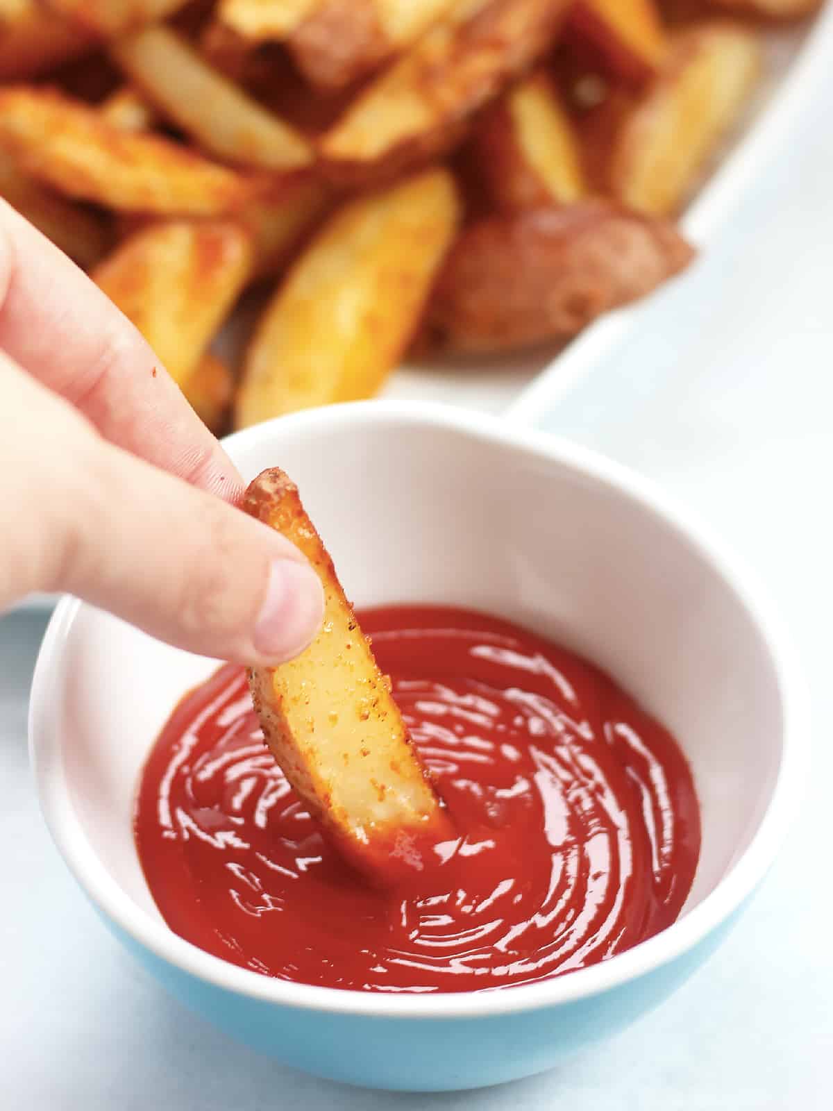 A fry being dipped into ketchup.