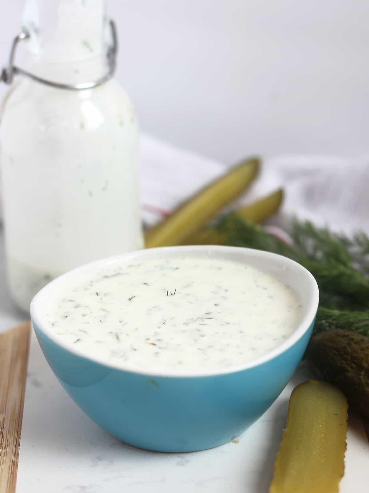 Dill pickle dip in a small blue bowl.
