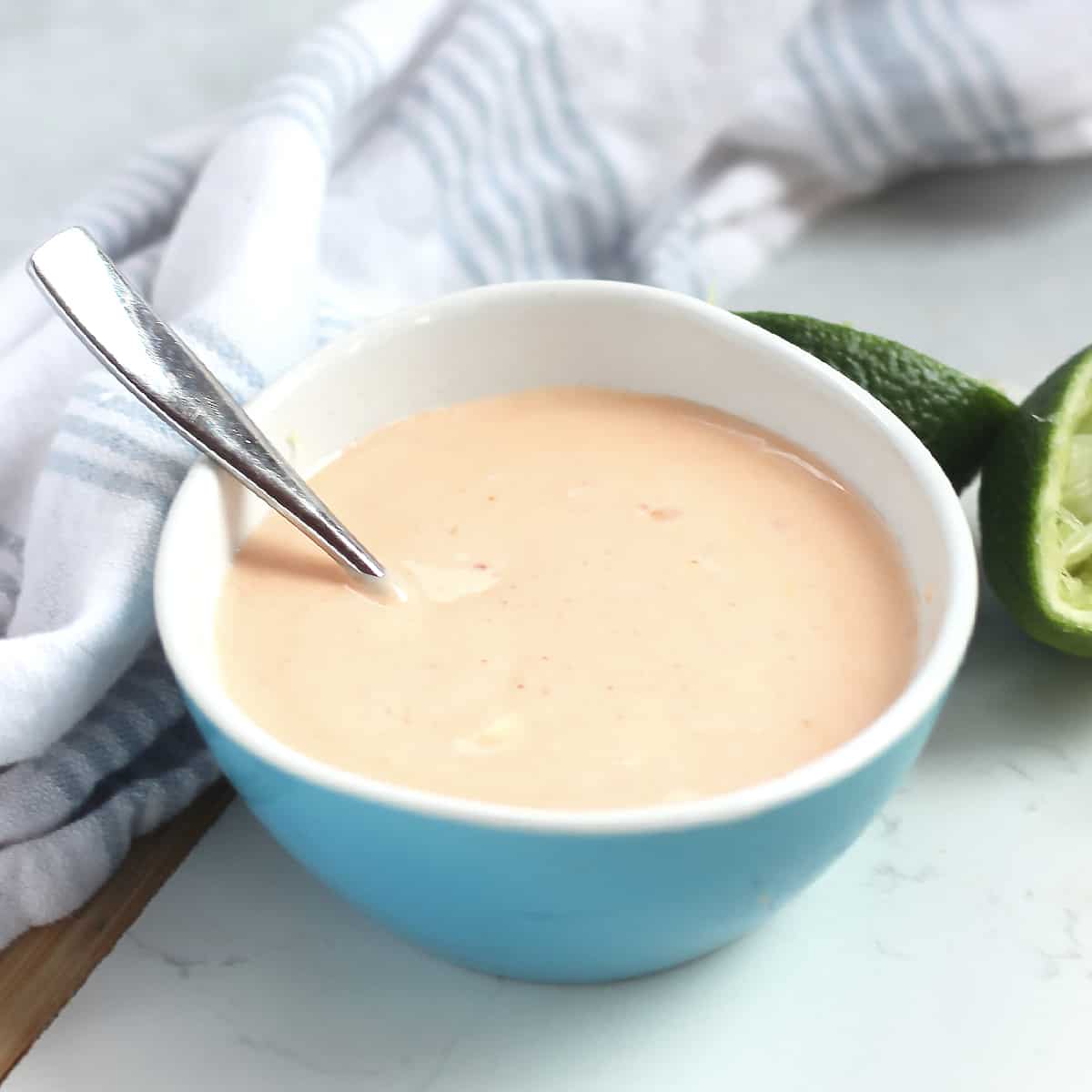 A spoon in a bowl of creamy sweet chili dipping sauce.