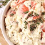 Sliced carrots in a cream sauce served in a bowl and garnished with fresh thyme.