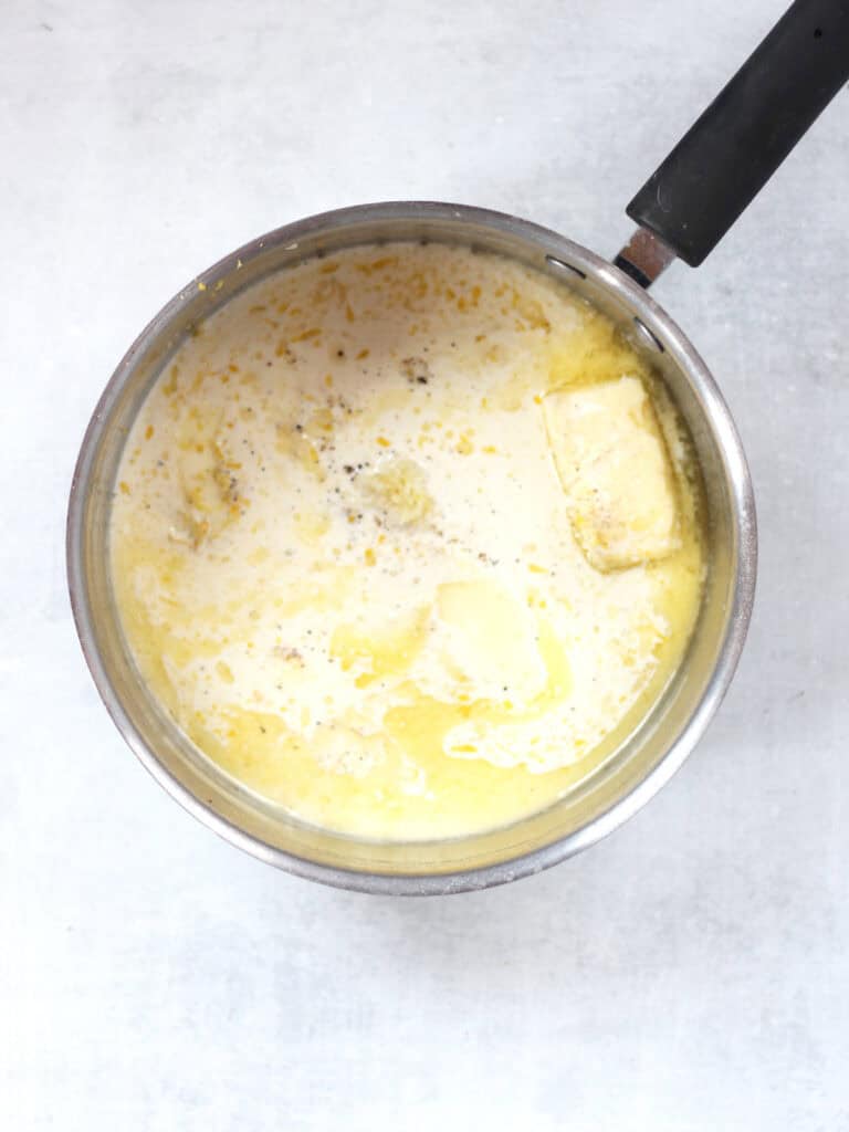 Butter, cream, lemon and seasonings in a silver pot.