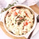 Creamed carrots served in a bowl with fresh thyme garnish.