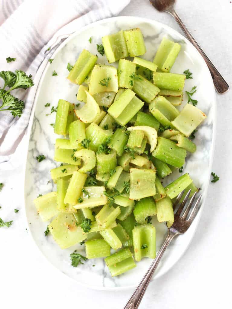 Air fried celery on a white plate with two forks.