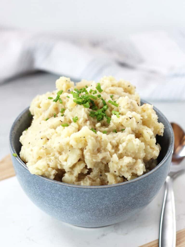 Black pepper mashed potatoes garnished with fresh chives.