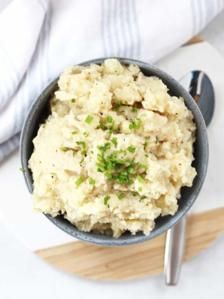 Black pepper mash in a blue bowl next to a serving spoon.