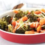 Roasted vegetables in a red serving bowl.