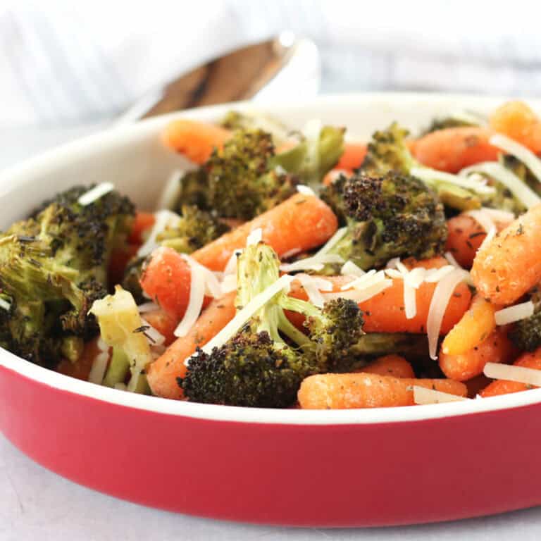 Roasted vegetables in a red serving bowl.