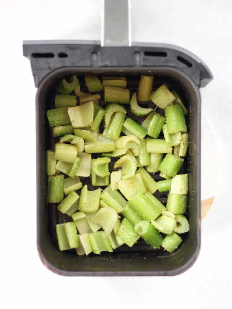 Celery in an air fryer basket.