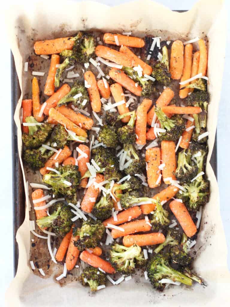 Roasted vegetables on a parchment lined baking sheet.