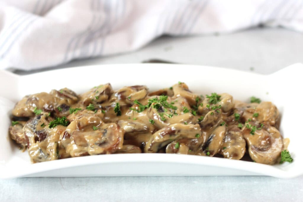 Creamy blue cheese mushrooms on a white serving plate.