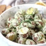 Baby red potatoes in creamy cottage cheese salad dressing, garnished with fresh dill.