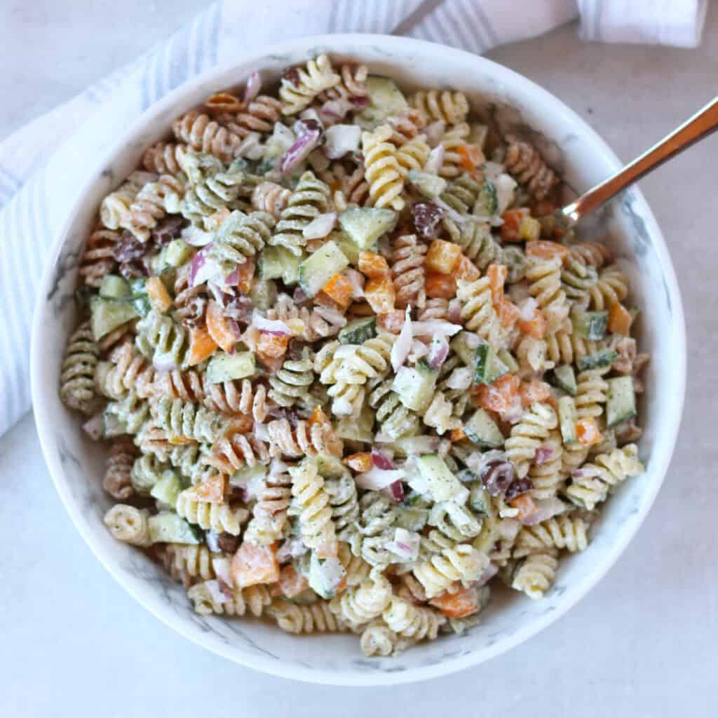 Cottage cheese pasta salad served in a large bowl with a spoon.