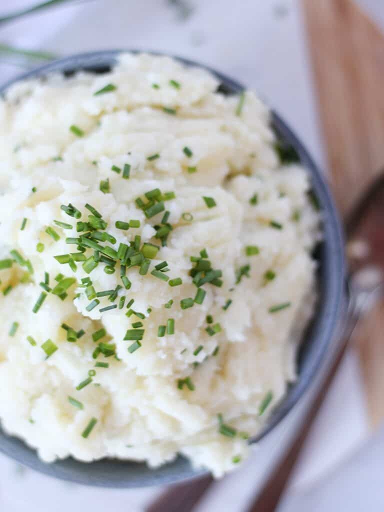 Chive garnish on top of fluffy mashed potatoes.