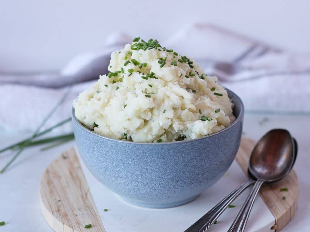 Cottage cheese mashed potatoes served in a bowl with two spoons.