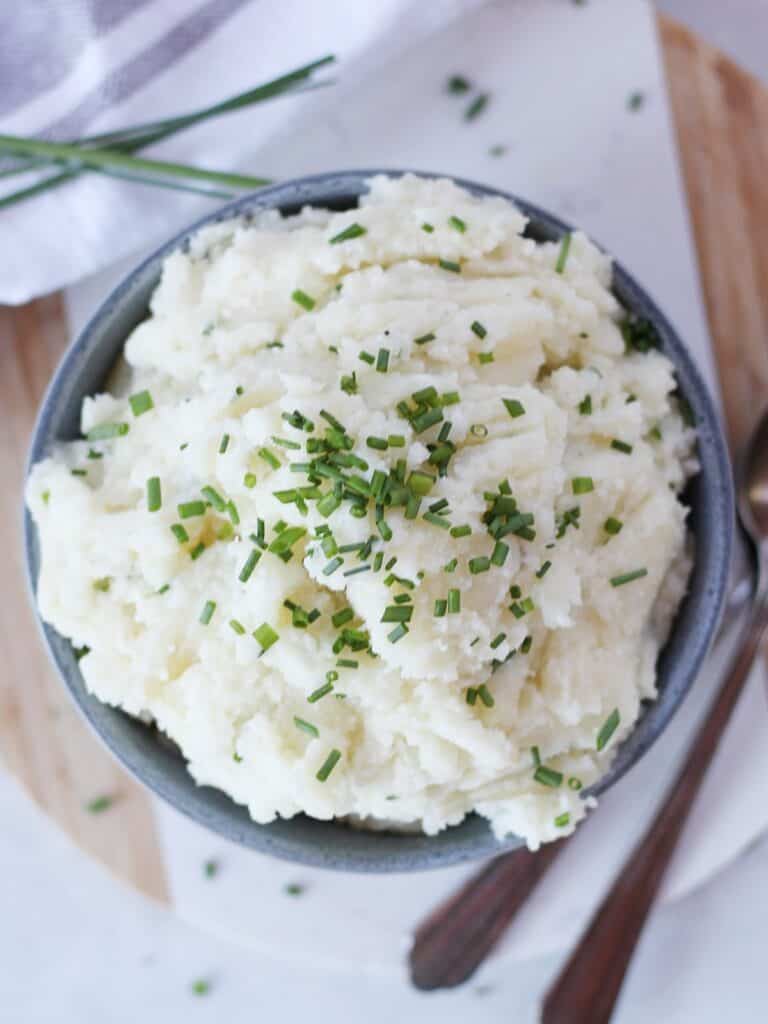 Creamy potato mash garnished with fresh chives.