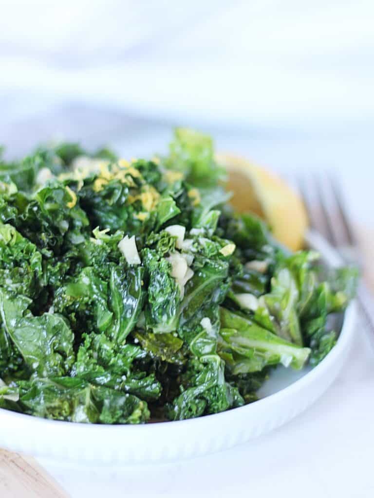 Garlic butter kale garnished with lemon zest.