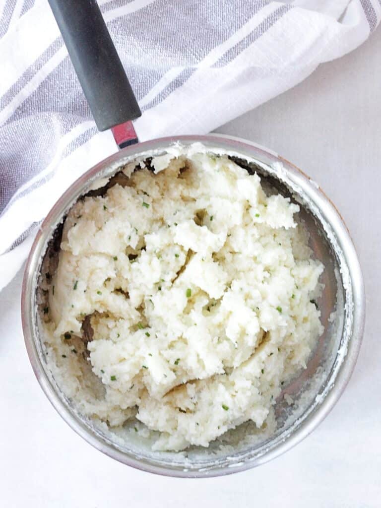 Cottage cheese mashed potatoes in a silver saucepan.
