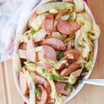 Sausage and cabbage served with parsley garnish.