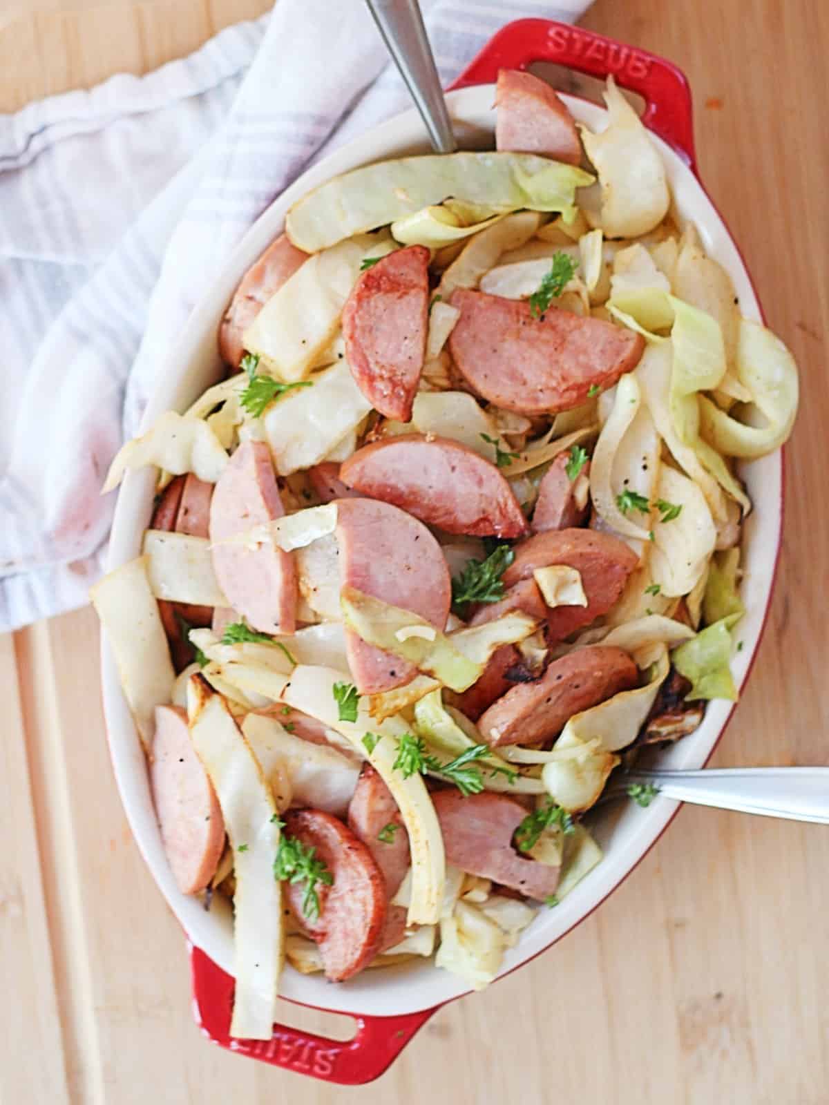 Sausage and cabbage served with parsley garnish.