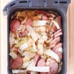 Kielbasa sausage and cabbage cooked in an air fryer basket.
