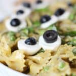 Mozzarella and olive 'eyeballs' on top of bowtie pasta.