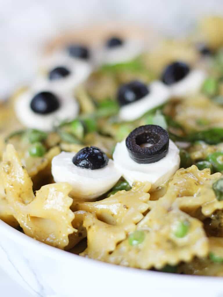 Mozzarella and olive 'eyeballs' on top of bowtie pasta.