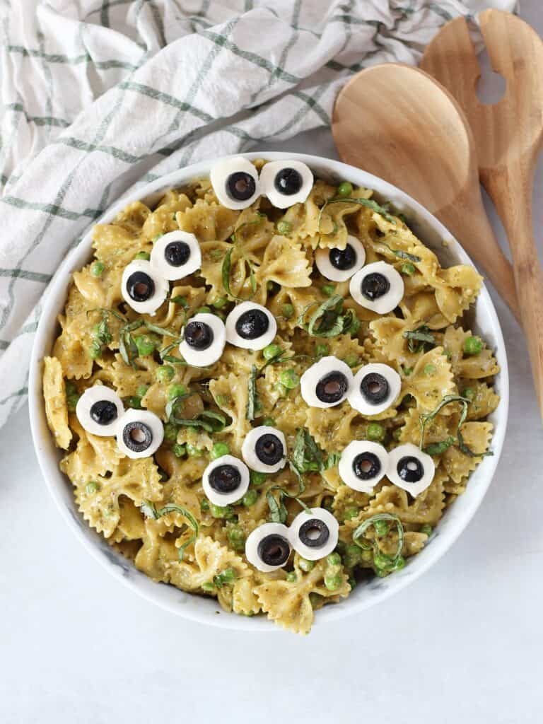 Green pesto pasta salad with mozzarella and olive 'eyeballs'.