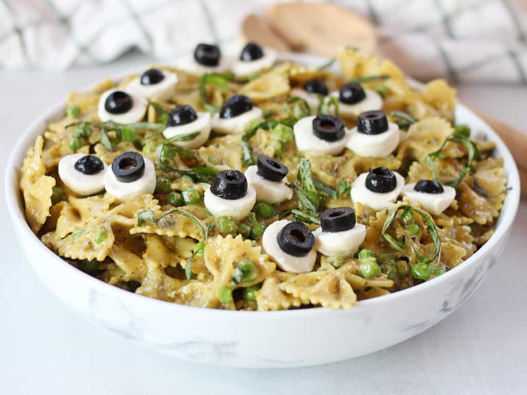 Bowtie pasta salad with pesto, mozzarella eyeballs and basil garnish.