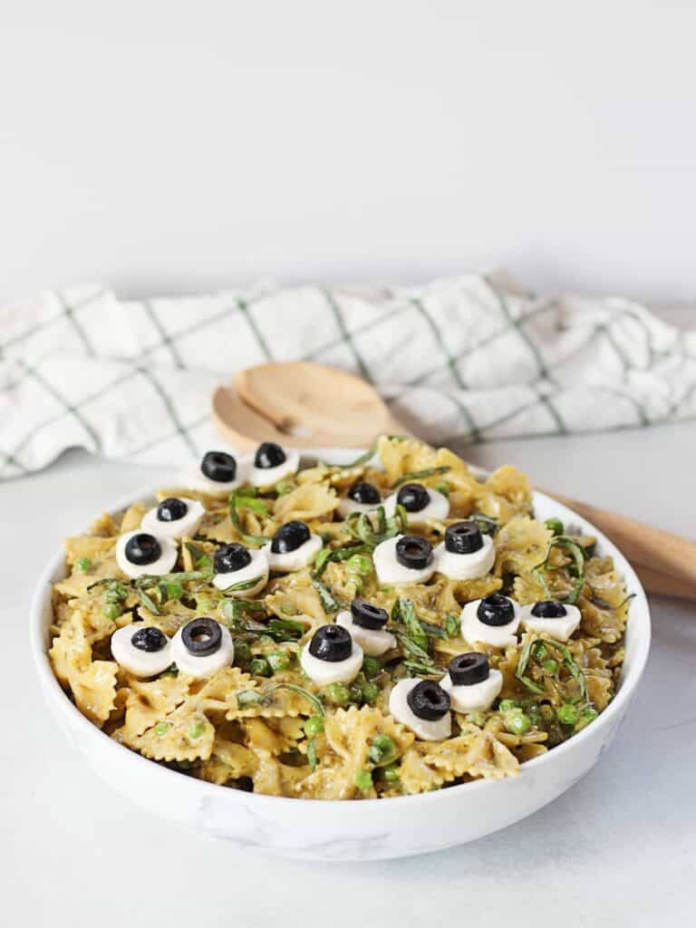 Halloween pasta salad served in a bowl with wooden serving spoons.